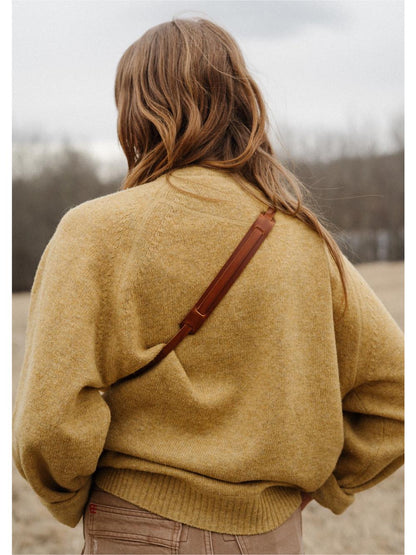 Girl wearing leather camera strap on a film camera Canon AE-1 Program